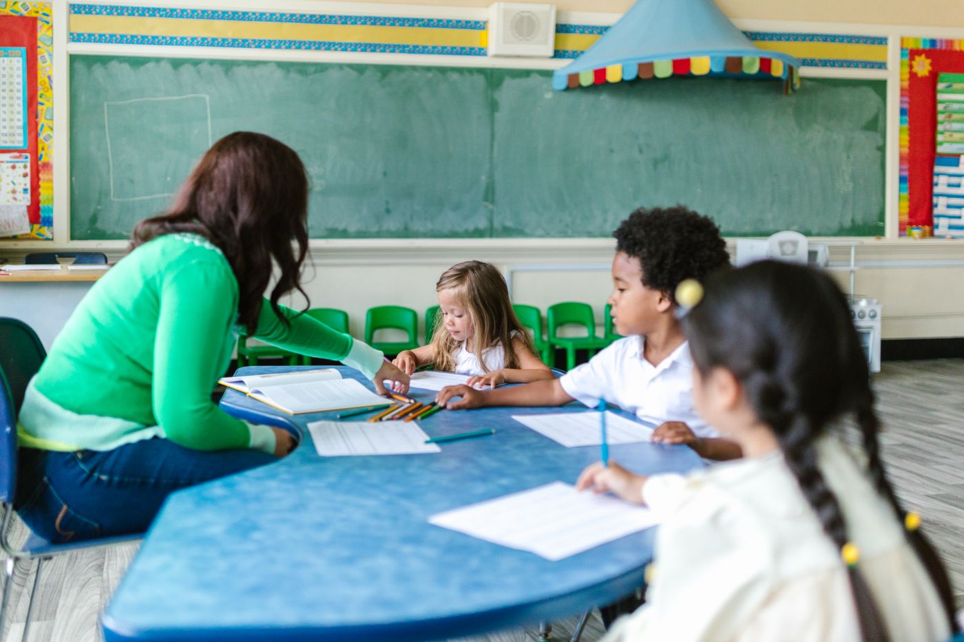 Teacher and young children learning together at a classroom table
